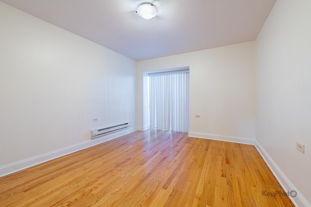 2318 S Central Park Ave Unit 101, Chicago, IL 60623 - empty room with a baseboard radiator and light wood finished floors