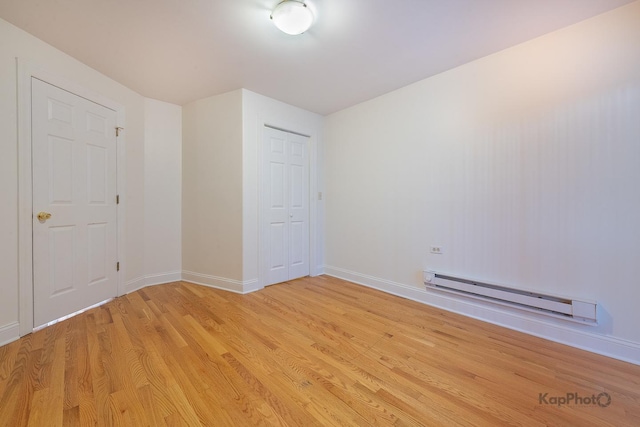 2318 S Central Park Ave Unit 101, Chicago, IL 60623 - unfurnished room featuring a baseboard heating unit and light wood-style flooring
