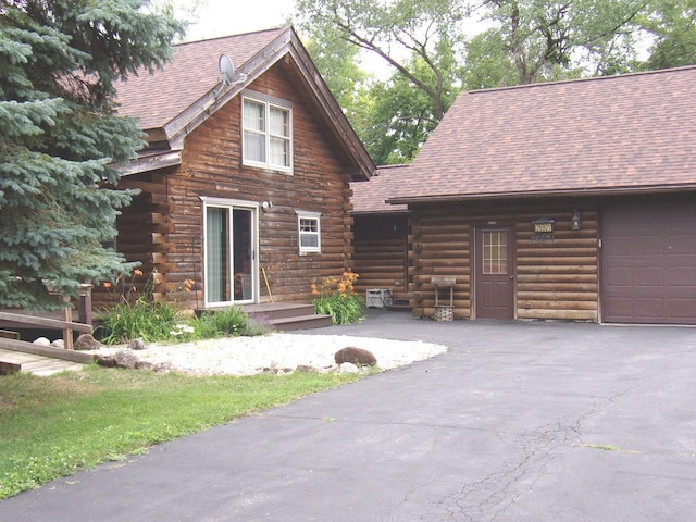 26901 W Burkhart Ln, Ingleside, IL 60041 - cabin with log siding, roof with shingles, an attached garage, and driveway