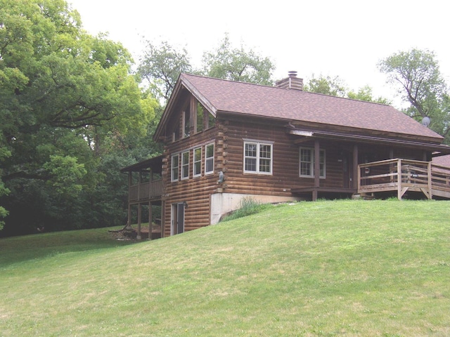 26901 W Burkhart Ln, Ingleside, IL 60041 - view of front of house featuring log siding, a front yard, a chimney, a wooden deck, and roof with shingles