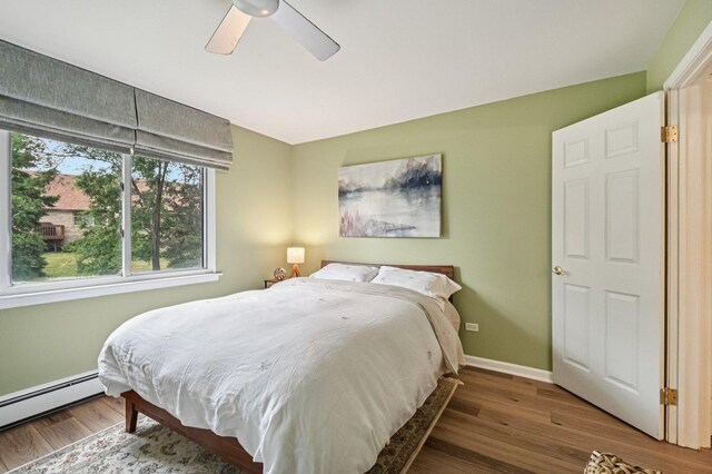 9S240 Lake Dr Unit 17-207B, Willowbrook, IL 60527 - bedroom featuring baseboard heating, wood finished floors, and a ceiling fan