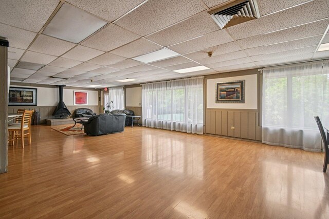 9S240 Lake Dr Unit 17-207B, Willowbrook, IL 60527 - living room with a wood stove, wood finished floors, wainscoting, and a paneled ceiling