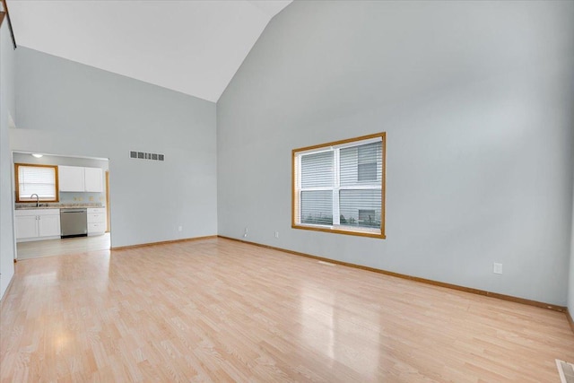 390 Madeline Trl, Rockford, IL 61107 - unfurnished living room with high vaulted ceiling and light wood-type flooring