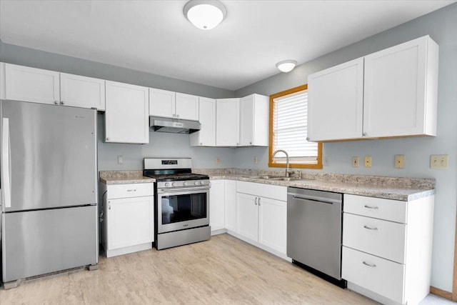 390 Madeline Trl, Rockford, IL 61107 - kitchen with stainless steel appliances, under cabinet range hood, white cabinets, and light countertops