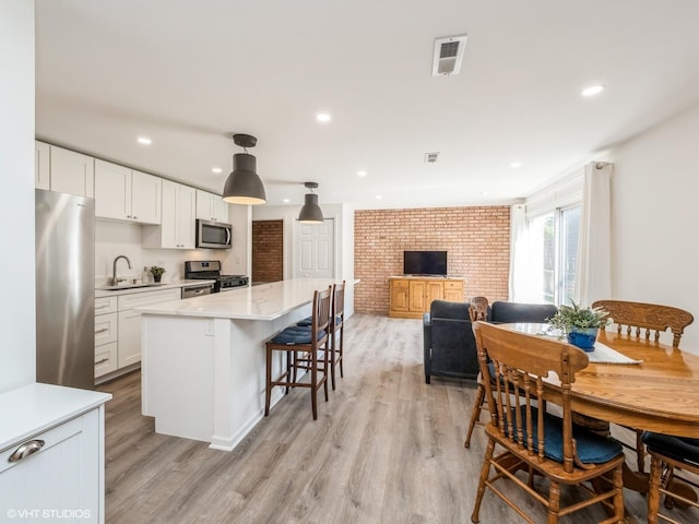 534 E Main St, Barrington, IL 60010 - kitchen with appliances with stainless steel finishes, light countertops, light wood-style flooring, white cabinets, and recessed lighting