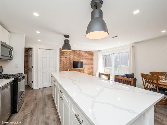 534 E Main St, Barrington, IL 60010 - kitchen featuring stainless steel appliances, white cabinets, recessed lighting, light wood-style floors, and decorative light fixtures