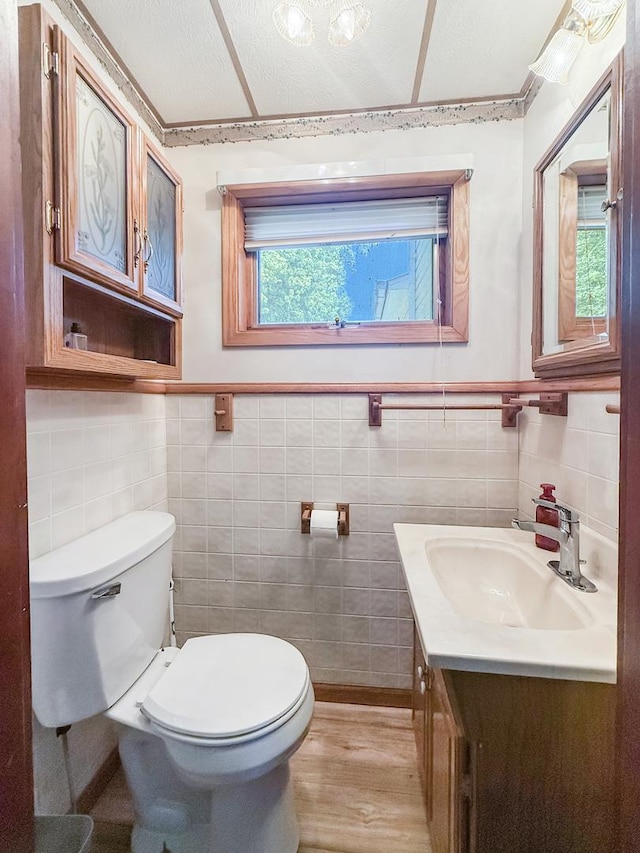 401 S Chestnut St, Shannon, IL 61078 - half bath featuring wood finished floors, vanity, tile walls, and a wainscoted wall