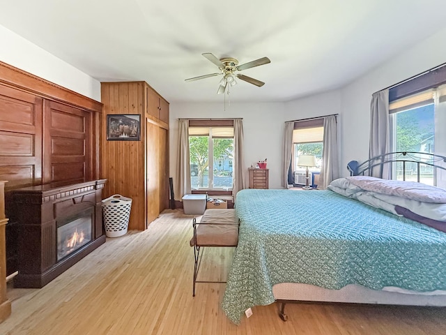 401 S Chestnut St, Shannon, IL 61078 - bedroom featuring light wood-type flooring, a glass covered fireplace, ceiling fan, and access to outside