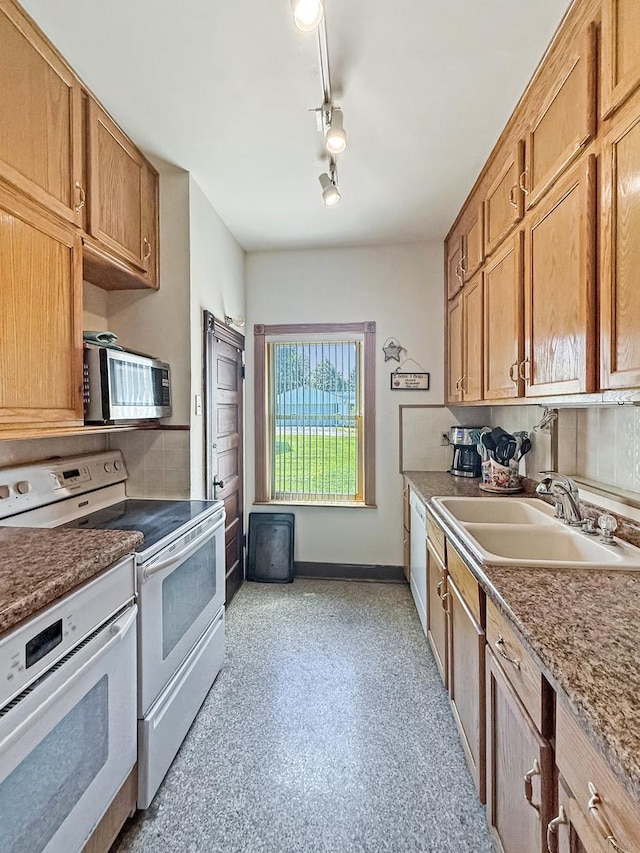 401 S Chestnut St, Shannon, IL 61078 - kitchen featuring white appliances, rail lighting, tasteful backsplash, and brown cabinetry