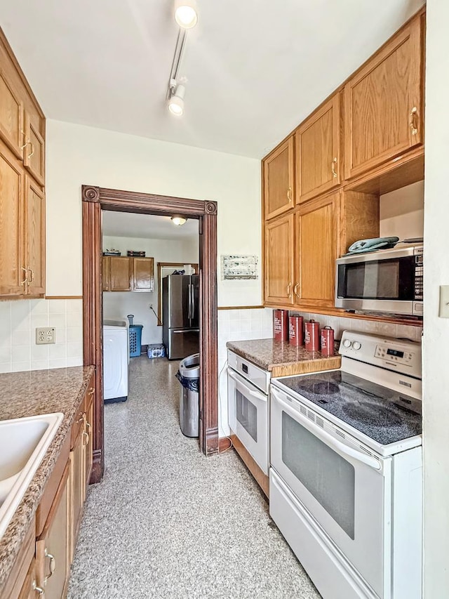 401 S Chestnut St, Shannon, IL 61078 - kitchen featuring appliances with stainless steel finishes, washer / clothes dryer, decorative backsplash, and brown cabinetry