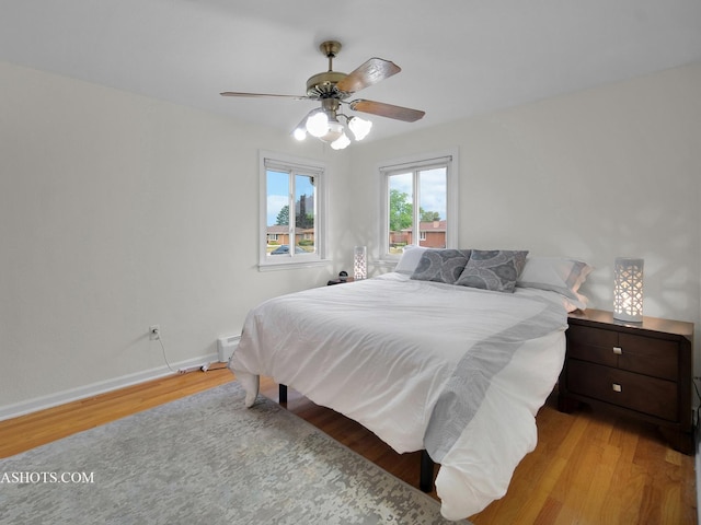 513 Chaney Ave, Crest Hill, IL 60403 - bedroom featuring wood finished floors, a ceiling fan, and a baseboard radiator