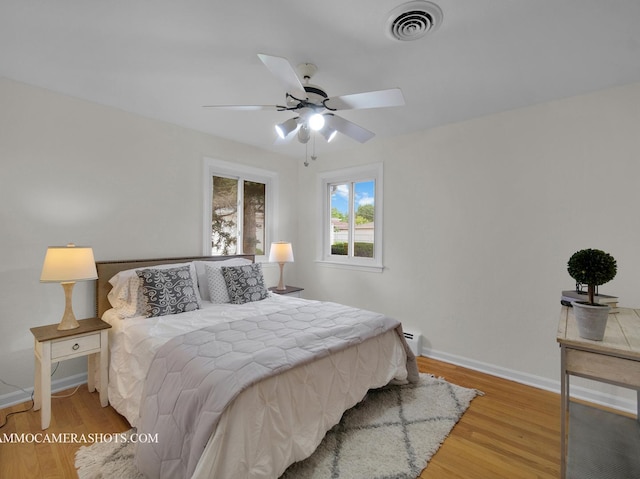 513 Chaney Ave, Crest Hill, IL 60403 - bedroom with light wood-style floors, baseboard heating, and ceiling fan