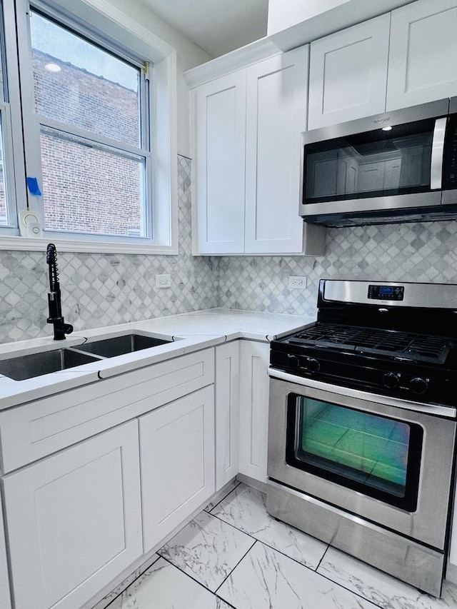 7253 S Marshfield Ave, Chicago, IL 60636 - kitchen with stainless steel appliances, light marble finish floors, light countertops, white cabinets, and tasteful backsplash