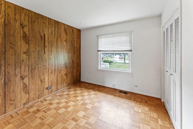 57 Kenilworth Ave, Elk Grove Village, IL 60007 - unfurnished bedroom featuring wood walls and a closet