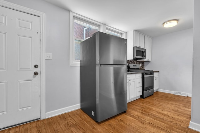 2059 Pine St Unit D, Des Plaines, IL 60018 - kitchen featuring appliances with stainless steel finishes, white cabinetry, light wood finished floors, and decorative backsplash