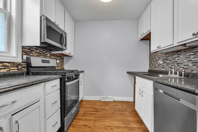 2059 Pine St Unit D, Des Plaines, IL 60018 - kitchen with stainless steel appliances, dark countertops, white cabinetry, and decorative backsplash