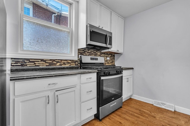 2059 Pine St Unit D, Des Plaines, IL 60018 - kitchen with appliances with stainless steel finishes, dark countertops, tasteful backsplash, white cabinetry, and light wood-type flooring