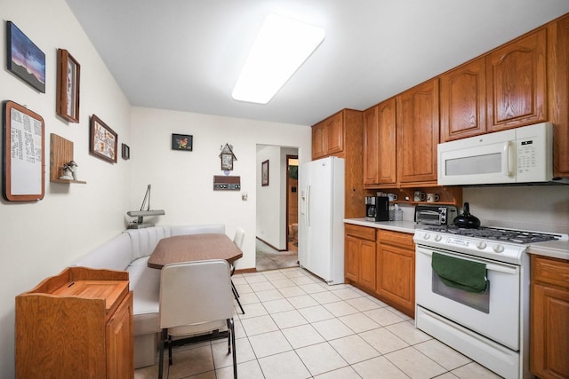 10S125 Springbrook Dr, Naperville, IL 60565 - kitchen featuring white appliances, brown cabinets, light countertops, and light tile patterned flooring