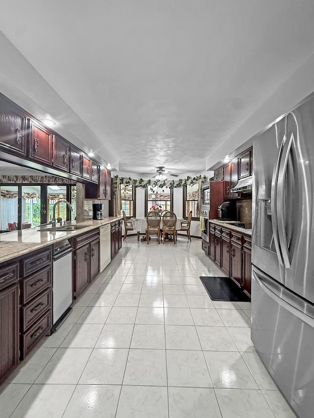 1607 Parkside Ct, Freeport, IL 61032 - kitchen with stainless steel appliances, reddish brown cabinets, light tile patterned floors, a ceiling fan, and light stone counters