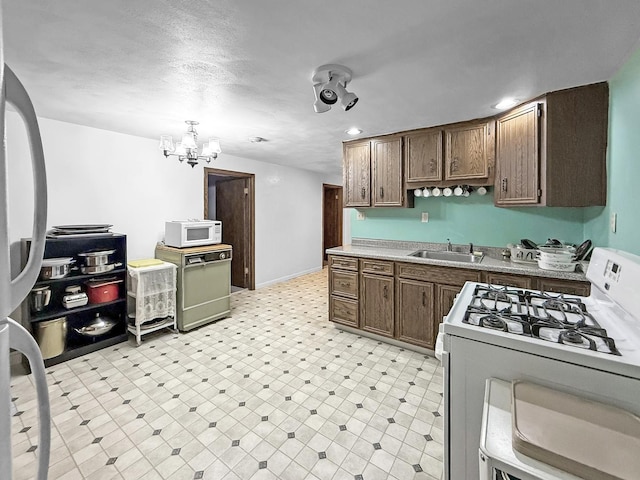 1607 Parkside Ct, Freeport, IL 61032 - kitchen with white appliances, a chandelier, light floors, light countertops, and recessed lighting