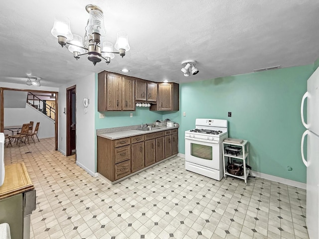 1607 Parkside Ct, Freeport, IL 61032 - kitchen with white appliances, light countertops, a chandelier, light flooring, and a textured ceiling
