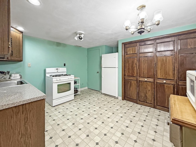 1607 Parkside Ct, Freeport, IL 61032 - kitchen with white appliances, light flooring, light countertops, and a chandelier