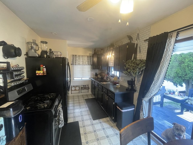 111 Earl Ave, Joliet, IL 60436 - kitchen with stainless steel gas range, ceiling fan, tasteful backsplash, dark countertops, and light floors