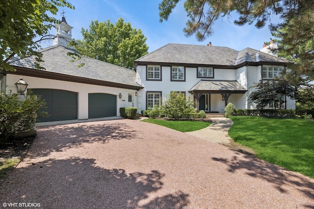 1604 Burr Ridge Clb, Burr Ridge, IL 60527 - view of front facade with a high end roof, asphalt driveway, stucco siding, a front lawn, and a garage