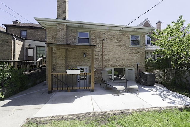 5848 N Drake Ave, Chicago, IL 60659 - back of house featuring a patio, brick siding, and a chimney