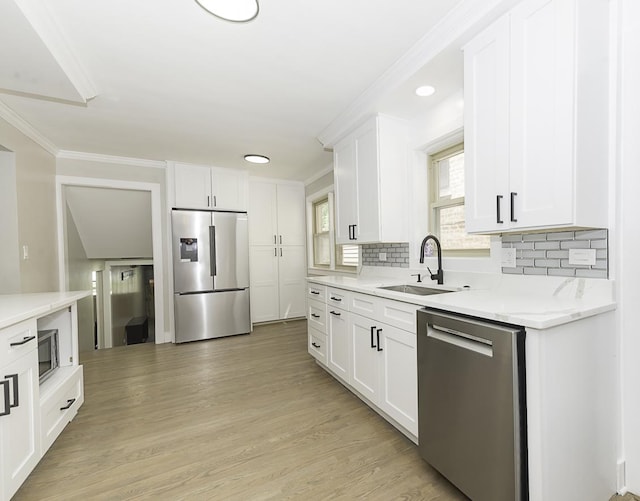 5848 N Drake Ave, Chicago, IL 60659 - kitchen featuring stainless steel appliances, ornamental molding, tasteful backsplash, white cabinetry, and light wood-style flooring