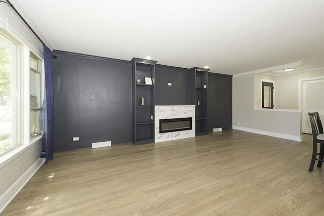 5848 N Drake Ave, Chicago, IL 60659 - unfurnished living room featuring crown molding, light wood-style floors, a premium fireplace, recessed lighting, and built in shelves