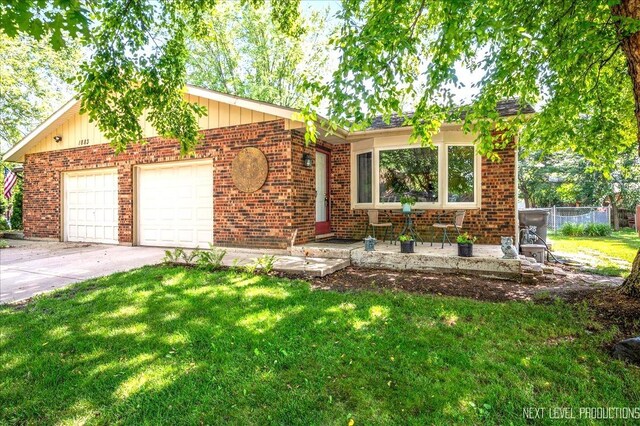 1885 Monday Dr, Elgin, IL 60123 - view of front of home featuring an attached garage, concrete driveway, and brick siding