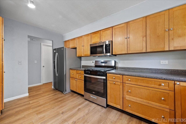 1885 Monday Dr, Elgin, IL 60123 - kitchen featuring appliances with stainless steel finishes, dark countertops, light wood-type flooring, and brown cabinets