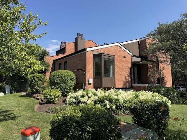 19W286 Governors Trl Unit 0, Oak Brook, IL 60523 - view of side of home with a chimney, brick siding, and a yard