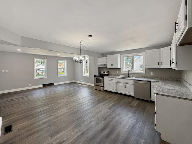 309 W S St, Pearl City, IL 61062 - kitchen with appliances with stainless steel finishes, a chandelier, white cabinetry, under cabinet range hood, and plenty of natural light