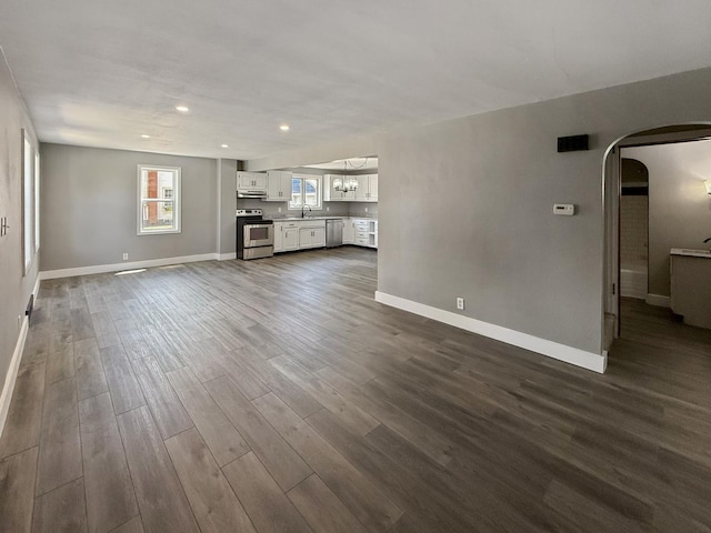 309 W S St, Pearl City, IL 61062 - unfurnished living room featuring arched walkways, dark wood-type flooring, recessed lighting, and a chandelier