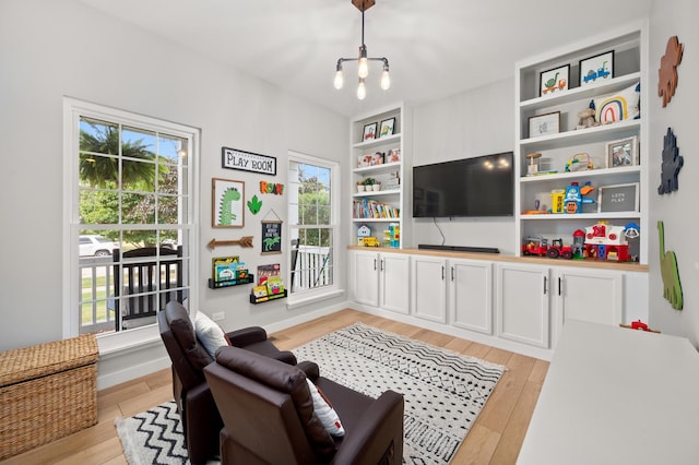203 Stearn Dr, Genoa, IL 60135 - living area with healthy amount of natural light, light wood-type flooring, and a chandelier