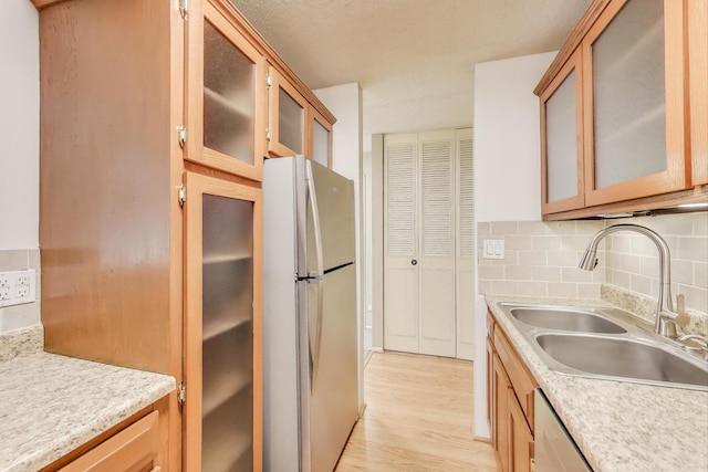 1227 S Old Wilke Rd Unit 304, Arlington Heights, IL 60005 - kitchen featuring freestanding refrigerator, light countertops, backsplash, light wood-type flooring, and glass insert cabinets