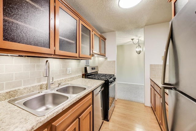 1227 S Old Wilke Rd Unit 304, Arlington Heights, IL 60005 - kitchen featuring appliances with stainless steel finishes, brown cabinetry, light wood-style floors, backsplash, and glass insert cabinets