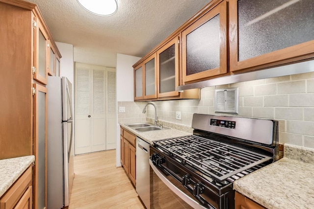 1227 S Old Wilke Rd Unit 304, Arlington Heights, IL 60005 - kitchen featuring appliances with stainless steel finishes, light wood finished floors, light countertops, brown cabinets, and a textured ceiling