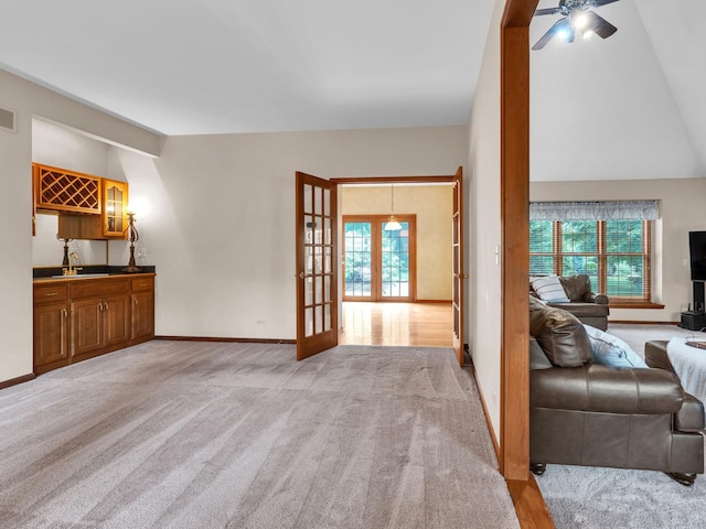 231 Deer Ln, Sleepy Hollow, IL 60118 - living room featuring vaulted ceiling, french doors, wet bar, light carpet, and a ceiling fan