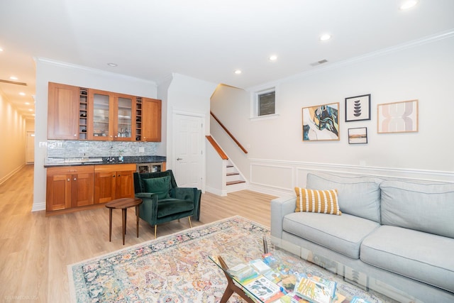 2418 N Southport Ave Unit 1, Chicago, IL 60614 - living room featuring stairway, ornamental molding, bar with sink, light wood-style flooring, and recessed lighting