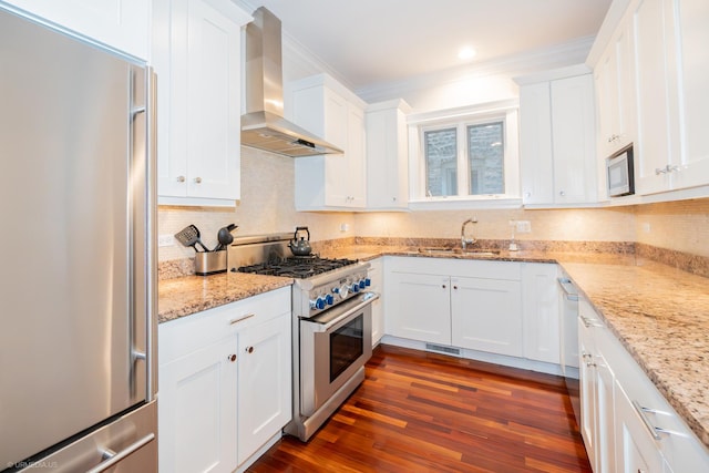 2418 N Southport Ave Unit 1, Chicago, IL 60614 - kitchen with high quality appliances, wall chimney range hood, white cabinets, dark wood-type flooring, and crown molding