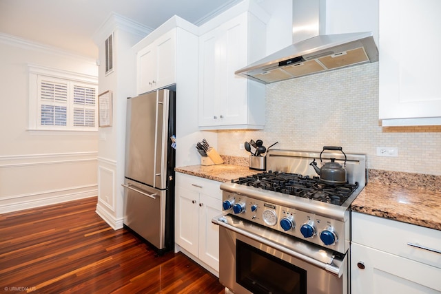 2418 N Southport Ave Unit 1, Chicago, IL 60614 - kitchen with wall chimney range hood, stainless steel appliances, decorative backsplash, dark wood-style flooring, and white cabinetry
