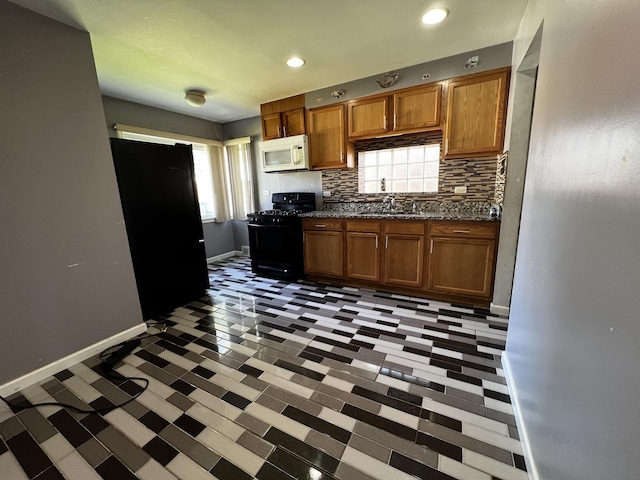 103 Morris St, Bellwood, IL 60104 - kitchen featuring black appliances, dark countertops, backsplash, plenty of natural light, and dark floors