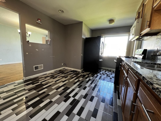 103 Morris St, Bellwood, IL 60104 - kitchen with range, dark stone counters, and white microwave