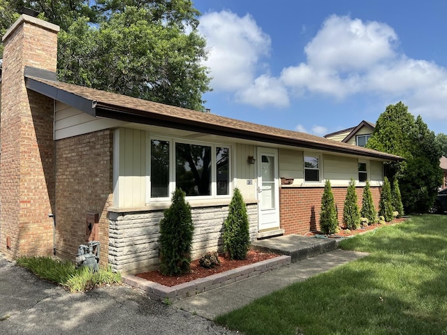 9128 Homestead Ln, Bridgeview, IL 60455 - view of front of property with a chimney, brick siding, a front yard, and stone siding