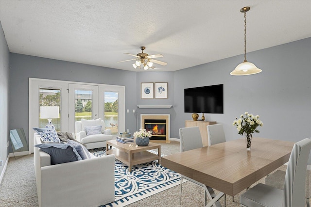 3718 Thornhill Dr Unit 0, Champaign, IL 61822 - living area featuring light colored carpet, a ceiling fan, a glass covered fireplace, and a textured ceiling