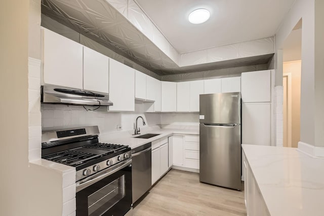 3041 S Michigan Ave Unit 501, Chicago, IL 60616 - kitchen featuring stainless steel appliances, under cabinet range hood, decorative backsplash, and white cabinets
