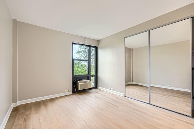 3041 S Michigan Ave Unit 501, Chicago, IL 60616 - unfurnished bedroom with light wood-type flooring, a closet, and an AC wall unit